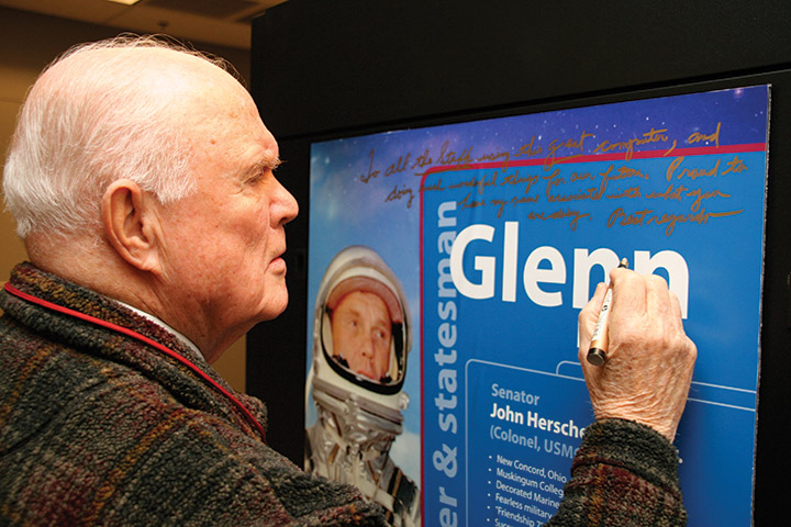 John Glenn signs poster on the Glenn Cluster.